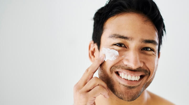 man applying cream to face