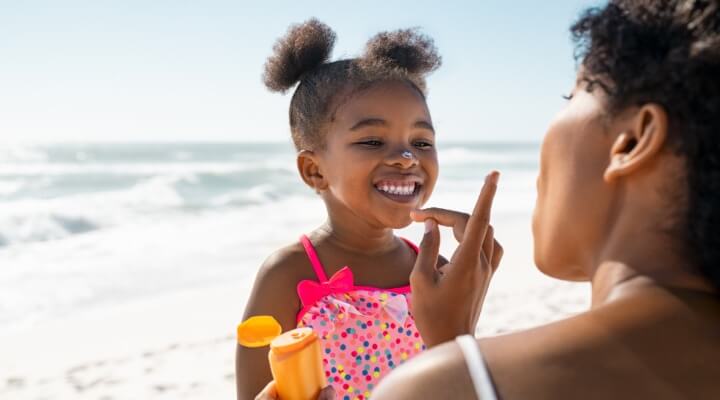 mom putting sunscreen on child
