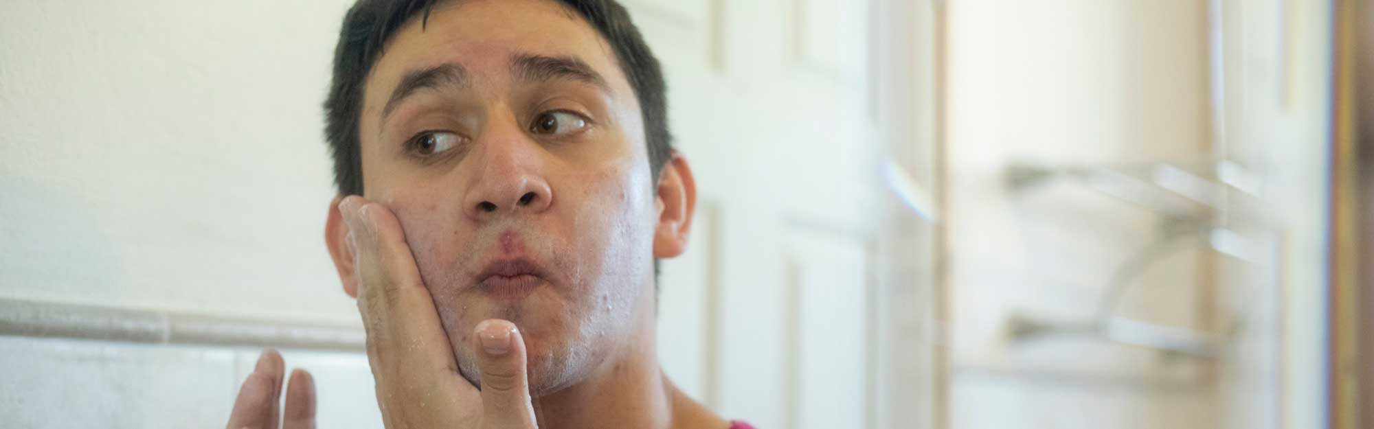 Male-touching-her-face-in-the-mirror