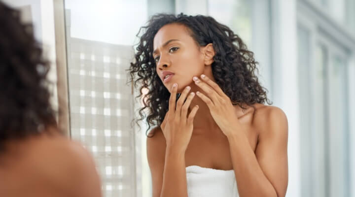 woman examining skin